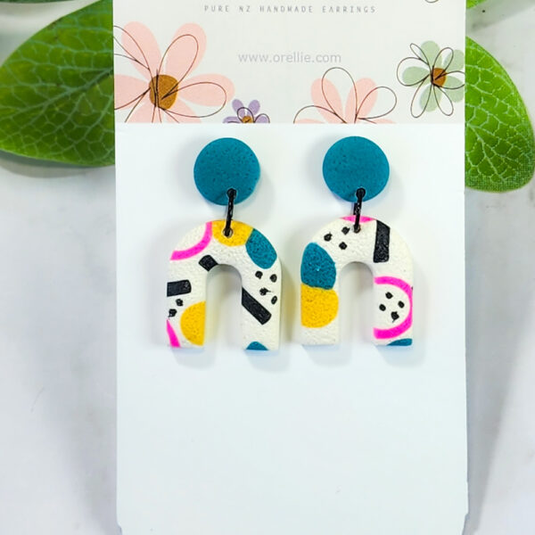 Embrace the playful spirit of Confetti Carnival with these arc-shaped stud earrings. Featuring vibrant colors and abstract patterns, these studs bring a touch of fun to any outfit.