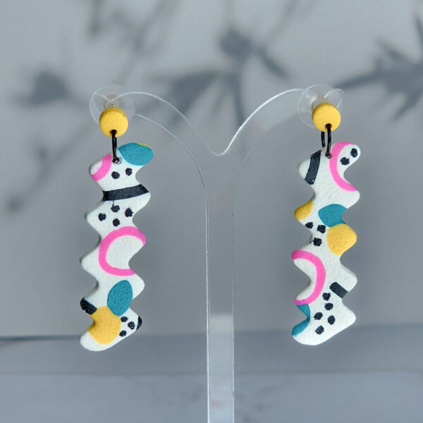 Make a bold statement with the Confetti Carnival zigzag dangles. These colorful earrings feature a unique abstract pattern that’s perfect for adding a playful touch to your look.