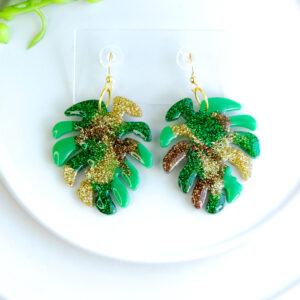 Add a touch of the wilderness to your style with the Forest Shimmer Ferns earrings by Orellie. These vibrant green and glittering statement earrings capture the beauty of forest ferns with a shimmer that brings your look to life.