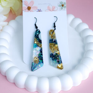 Step into a burst of color with the Aqua Bloom earrings. These vibrant handmade earrings feature unique floral shapes with a pop of aqua blue, perfect for adding a fun touch to any outfit.