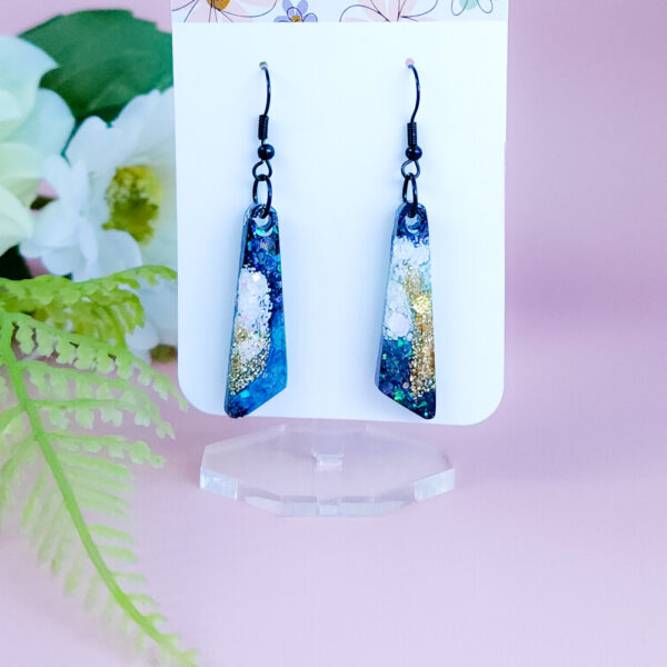 Step into a burst of color with the Aqua Bloom earrings. These vibrant handmade earrings feature unique floral shapes with a pop of aqua blue, perfect for adding a fun touch to any outfit.