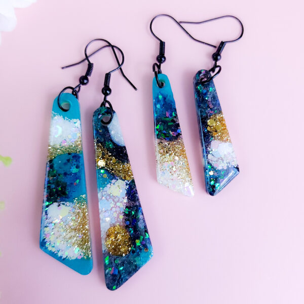 Step into a burst of color with the Aqua Bloom earrings. These vibrant handmade earrings feature unique floral shapes with a pop of aqua blue, perfect for adding a fun touch to any outfit.