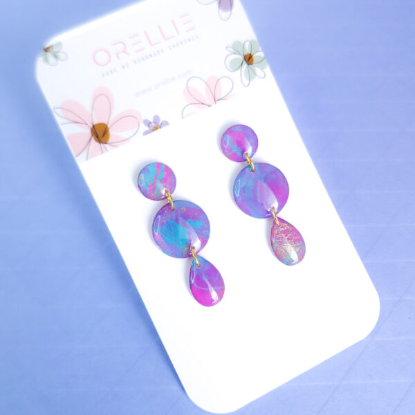 Brighten up your look with the hand-painted Pixie Pop Triple Drop earrings. These vibrant, colorful drops add playful charm to any outfit, perfect for standing out in style.