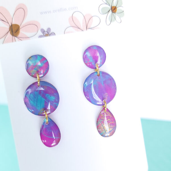 Brighten up your look with the hand-painted Pixie Pop Triple Drop earrings. These vibrant, colorful drops add playful charm to any outfit, perfect for standing out in style.